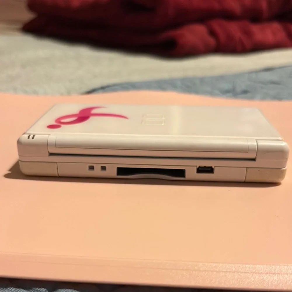 White Handheld Gaming Console with Pink Ribbon